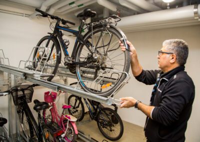 Fastighetstekniker ställer upp en cykel i ett cykelställ